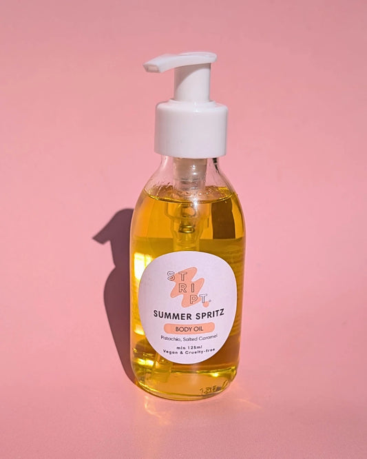Summer Spritz Body Oil by Stript Cosmetics | Handmade, Vegan Body Care | Bottle of Summer Spritz body oil on a pink background